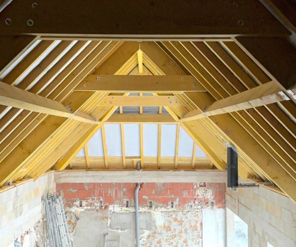 Charpente bois apparente à l’intérieur d’une maison en reconstruction