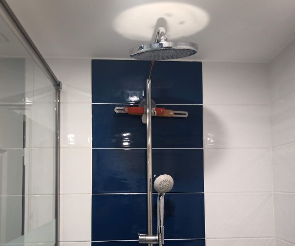Douche carrelée bleue et blanche installée après surélévation