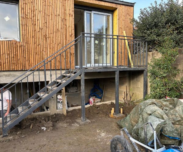 Extension terminée avec bardage bois et escalier métallique